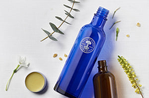 Picture of our bottles on a canvas and botanicals background - Neal's Yard Remedies